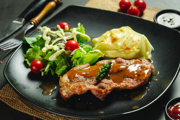Food shot pork steak with mashed potato and salad