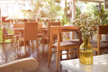flowers in a vase on the table with interior of restaurant