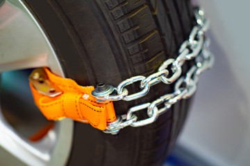 Chains for riding in the snow. Anti-slip agent. Chain on wheels against slipping. Driving safety in winter. Chains are mounted on the wheel of a car. Ensuring safe driving in the snow. Anti-slip agent