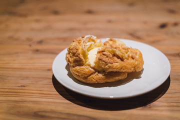 Freshly baked Vanilla Choux Cream Puff on white plate.
