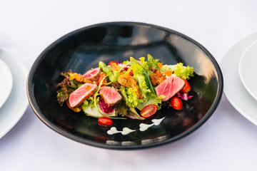 Medium Rare Tuna Salad (Green Coral, Red Coral, Tomato and Salmon Roe) with Touched Sea Urchin in black plate.