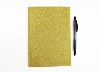Gold notebook and black pen on white background