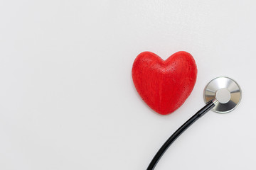Conceptual flat lay overhead red heart and medical stethoscope on white background. Template for prophylaxis of heart diseases. World Heart Day concept.  Medical insurance concept.