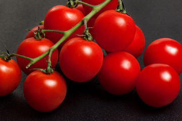 a bunch of fresh organic cherry tomatoes on a dark background