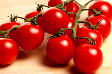 a bunch of fresh organic cherry tomatoes on a wooden background
