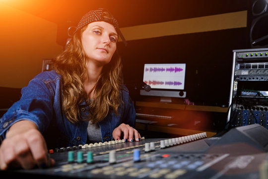 A woman controls the sound mixer. The girl at the remote in the recording Studio. Professional vocal recording at the Studio.