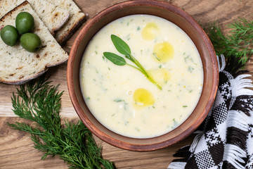 Fresh hot onion soup with cheese, fresh sage leaves, olive oil and spices top view. Healthy homemade food concept.