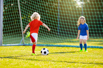 Kids play football. Child at soccer field.