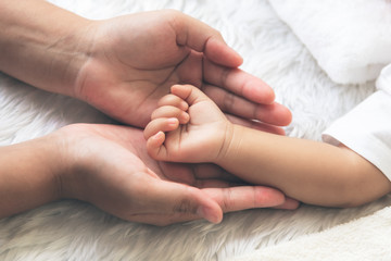 Baby's hand Placed on the mother's hand, concept to showing love and concern for her children, And is love family relationship.