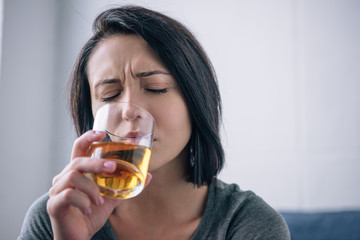 lonely depressed woman drinking whiskey at home