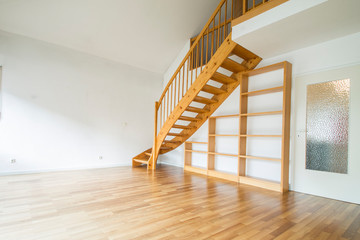 leerer Raum mit Holztreppe und weißen Wänden