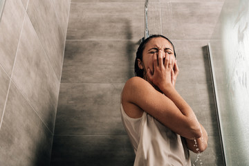 lonely sad woman crying in shower at home with copy space