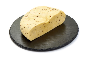 Sliced Cheese with cumin seeds on a stone plate, isolated on white background