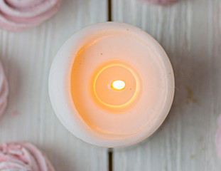 Zephyr lined in a circle shape with burning candles on a white background. Flat lay. Top view. Pink sweet homemade zephyr or marshmallow. Colorful meringues on white. top view dessert image.