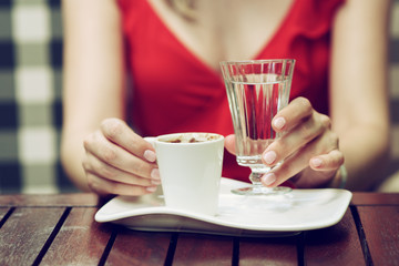 Close up of beautiful female hands holding white cup of coffee.