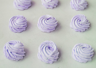 Meringue zephyr marshmallows on a light background. purple sweet homemade marshmallow. meringue on white background.