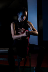 Fototapeta na wymiar Young female boxer prepare for training in a gym.