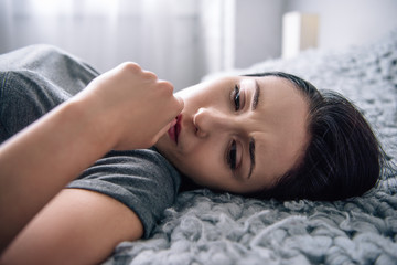 Fototapeta premium selective focus of beautiful depressed woman lying on bed at home