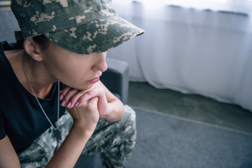 sad woman in military uniform at home with copy space