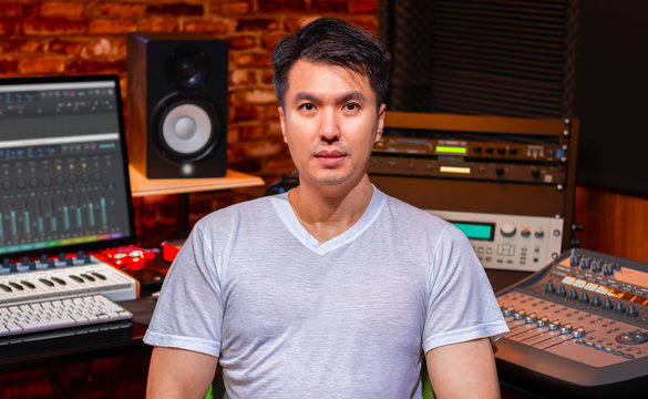 portrait of asian handsome music producer in home recording studio