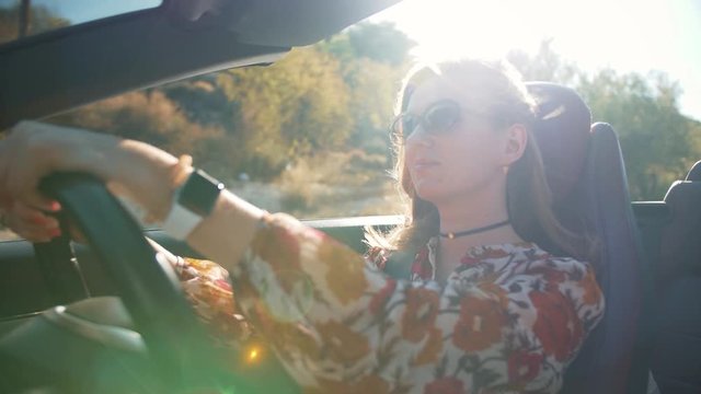 Woman driving a convertible car on sunny day. SLOW MOTION