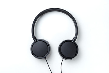 Black headphones isolated on white background. Flat lay top view copy space. Music concept. Minimal style