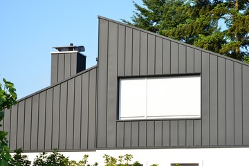 Stehfalz-Metall-Fassadenverkleidung des Dachgeschosses an einem modernen Einfamilienhaus