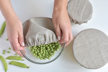 Reusable bowl covers set, woman hands cover bowl with fresh peas, zero waste kitchen