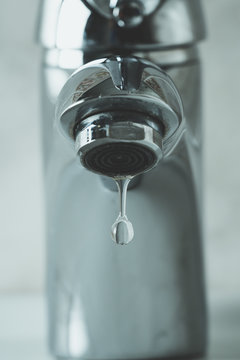 water drop dripping from the tap and water shortage