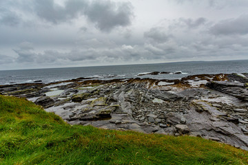 Beautiful Irish limestone landscape on the coast in the coastal walk route from Doolin to the Cliffs of Moher, geosites and geopark, Wild Atlantic Way, rainy day in county Clare in Ireland