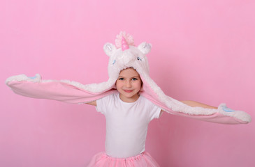 Smiling caucasian beautiful little girl in a hat with  unikorn