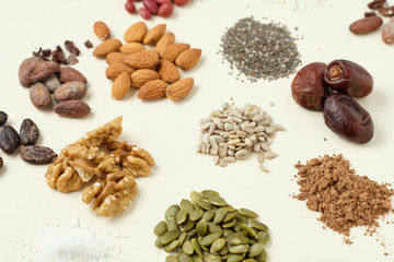 Various superfoods top view. Superfood as coconut powder, spirulina, raw cocoa bean, kerob, walnut, peanut, sunflower and pumpkin seeds.