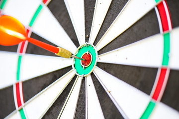 Close-up image with a dart in the bullseye of a practice target
