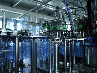 Filling line of sparkling water in pet bottle. Mini factory for