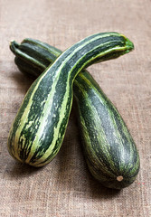 Fresh striped zucchini on sackcloth background