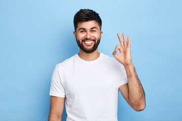positive attractive Arab young man showing ring gesture with fingers.close up portrait, good job, agreement concept. I am OK, approval. studio shot.guy being satisfied with suggestion