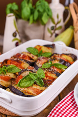 Traditional italian food. Baked eggplant, tomatoes with sauce, parmesan and basil. Rustic food for a healthy diet. Vegetables for lunch.