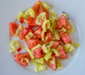 Top view of plate with salad made of tomatoes and paprika with olive oil
