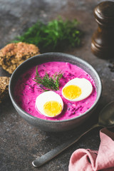 Cold beetroot soup with boiled egg in a bowl. Selective focus, toned image