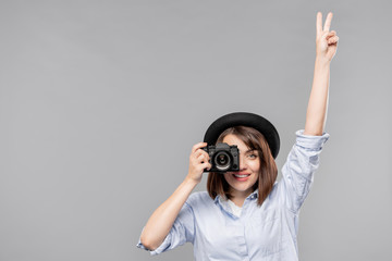 Young woman in smart casualwear showing peace gesture while taking photo