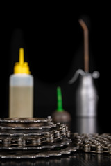 Oiling the bicycle chain with an oil can on the workshop table. Servicing of bicycle parts.