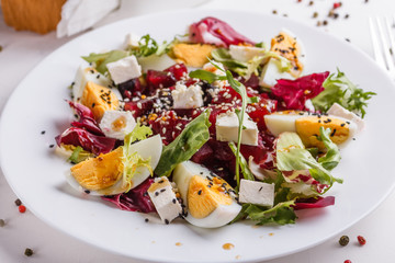 Fresh mixed salad in a bowl on a white background