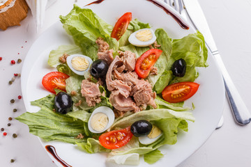 Fresh salad with iceberg lettuce,tomatoes,eggs,canned tuna and olives