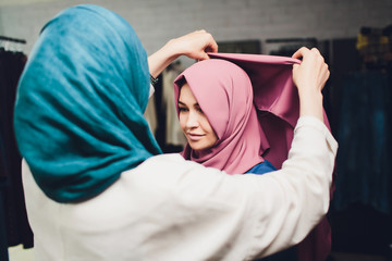 Arab woman in traditional Muslim clothes buys a new dress in an Oriental store.