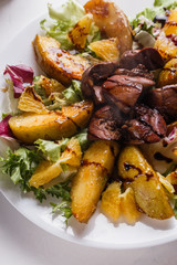 Baked potatoes with boiled chicken liver on a plate