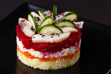 Russian salad herring under fur coat on a dark background