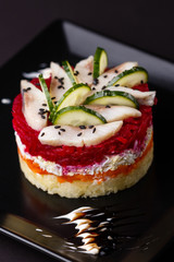 Russian salad herring under fur coat on a dark background