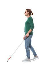 Blind man in dark glasses with walking cane on white background