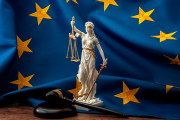 European union court of justice or ECJ, legal system in Europe and the legislature branch of government concept with a gavel, a statue of Themis the lady of justice and the EU flag - obrazy, fototapety, plakaty