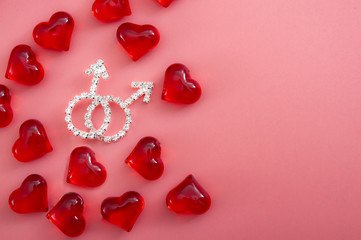Gay marriage, homosexuality and LGBT couple concept theme with two mars symbol with crystals and diamonds surrendered by red hearts representing love, isolated on pink background with copy space